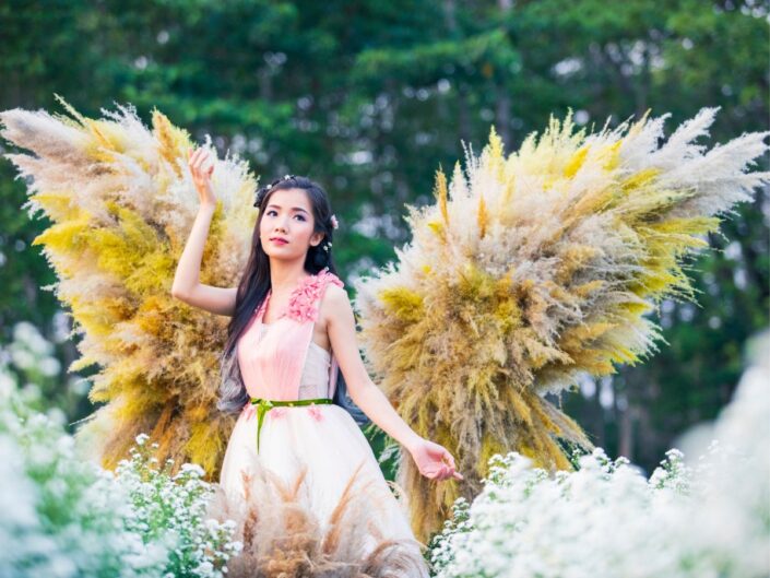 Angyalszárnyakat viselő fiatal nő tavasszal