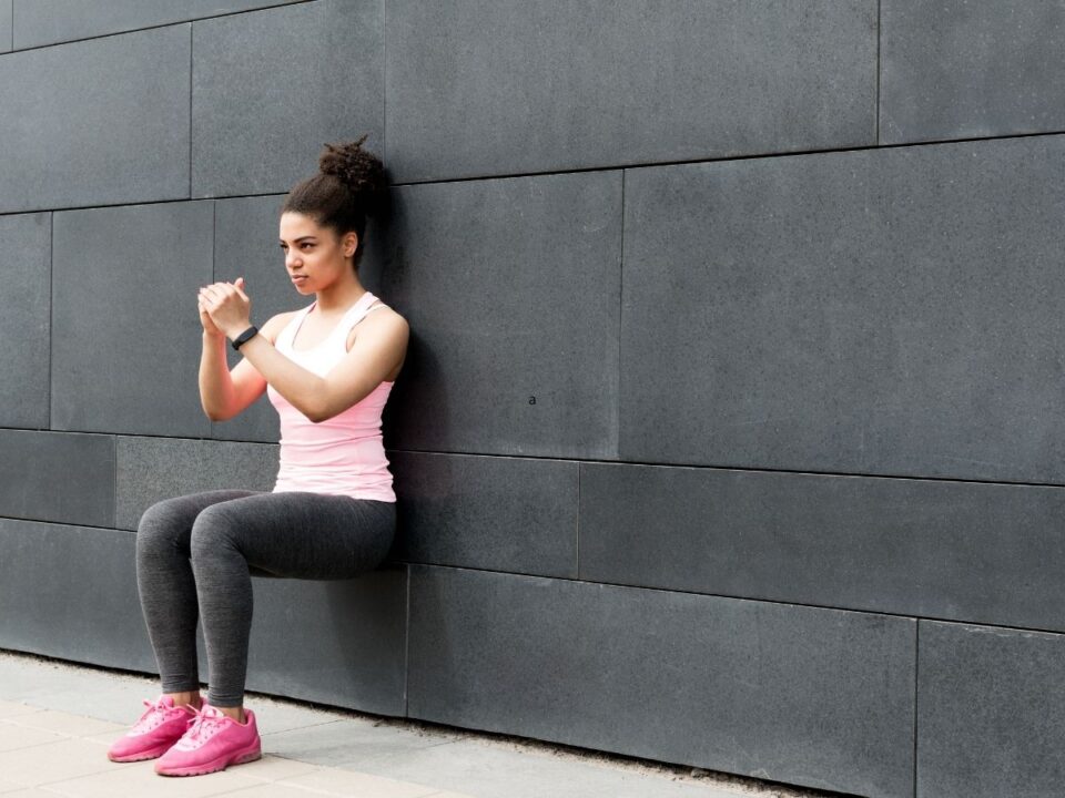 falnál guggoló nő