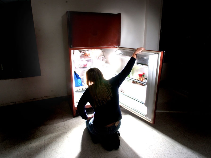 nő este a hűtőbe bámul