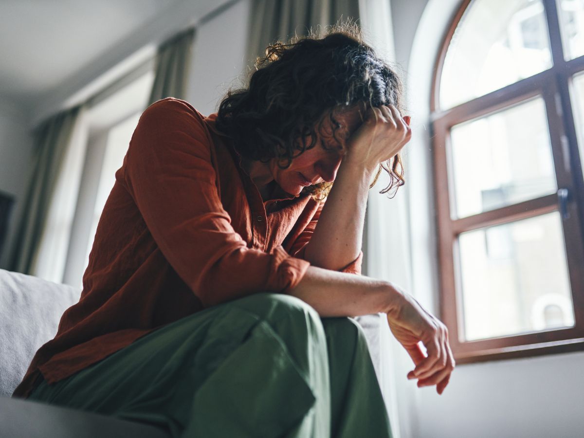 nő előrehajol fáradt fogja a fejét