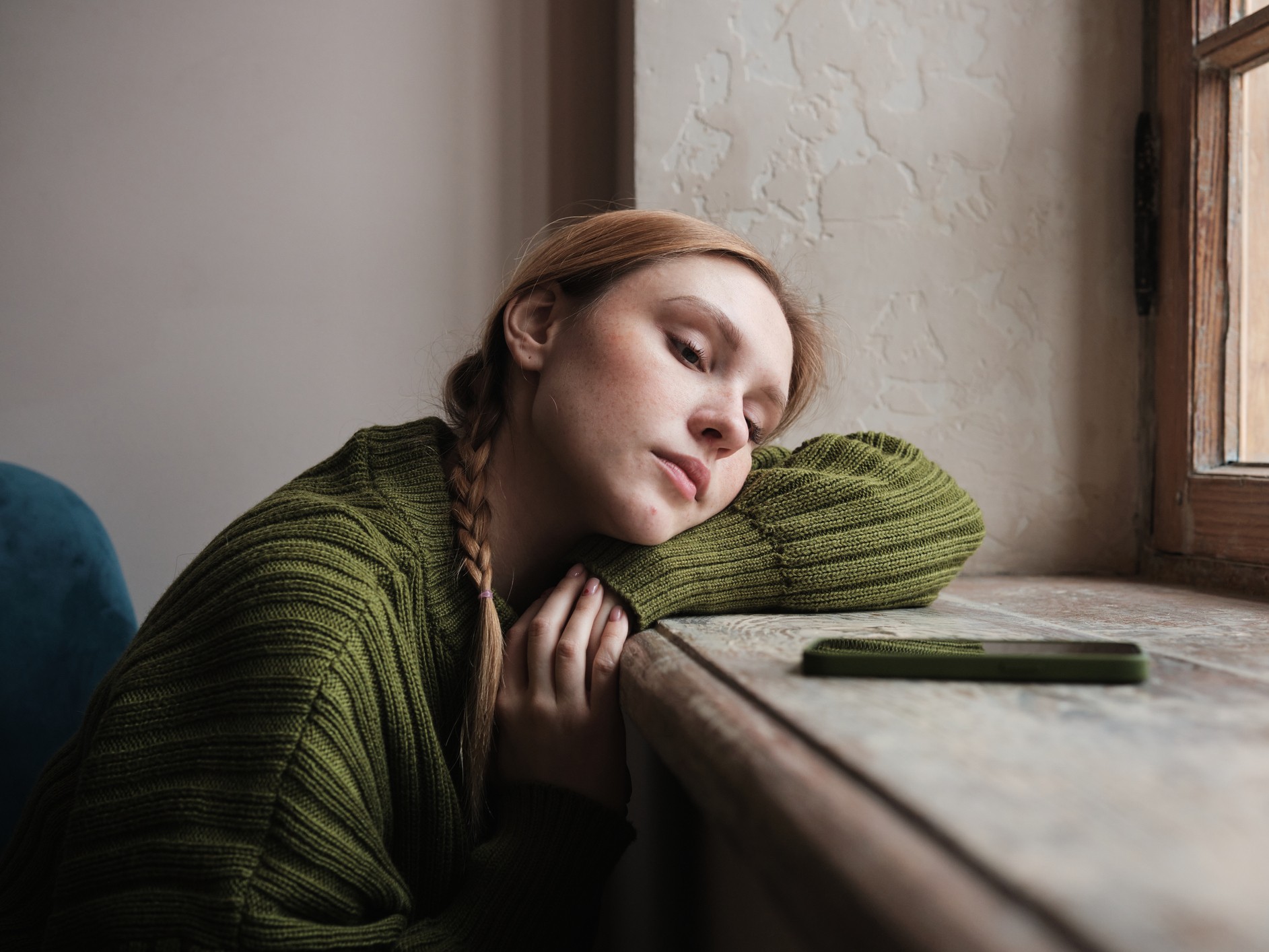 szomorú nő nézi a telefonját