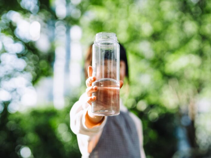 zöld háttér nő kezében kulacs víz