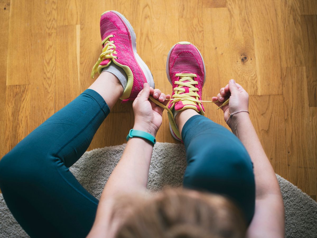 nő ülve köti a cipőfűzőjét