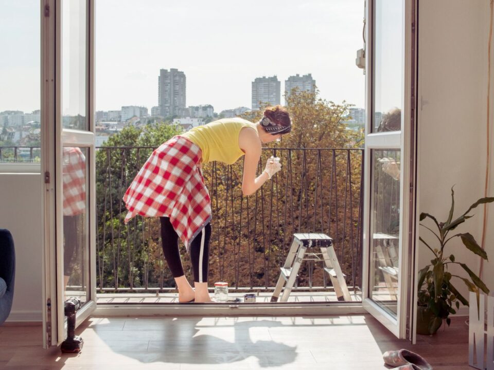 fiatal nő erkélyt takarít tavasszal 