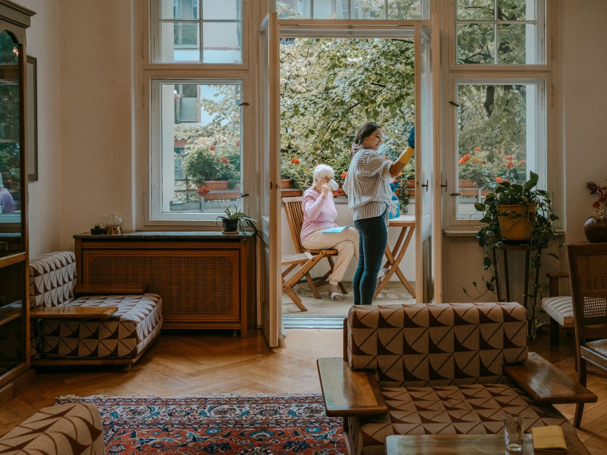 fiatal nő erkélyt takarít tavasszal