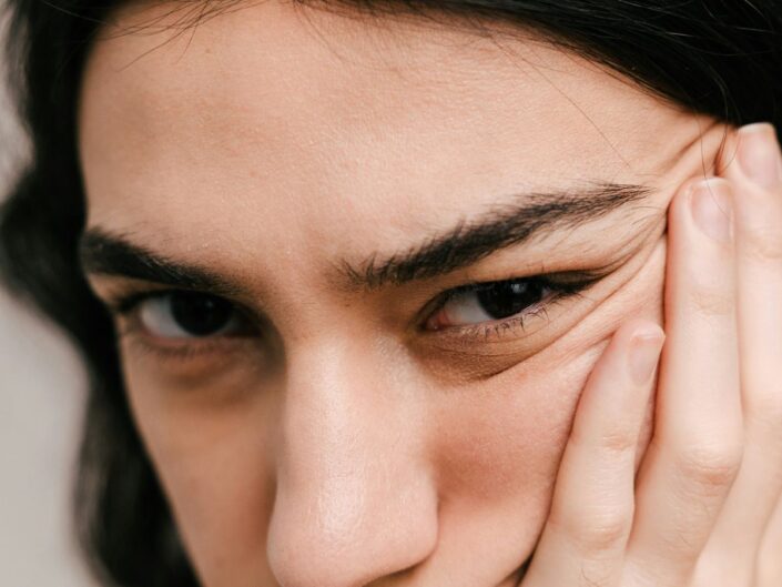 Nárcisztikus személy arca közeli képen, kezével húzza az egyik arcát oldalt