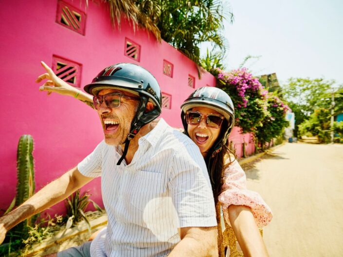boldog középkorú pár egy motoron robok pink ház előtt