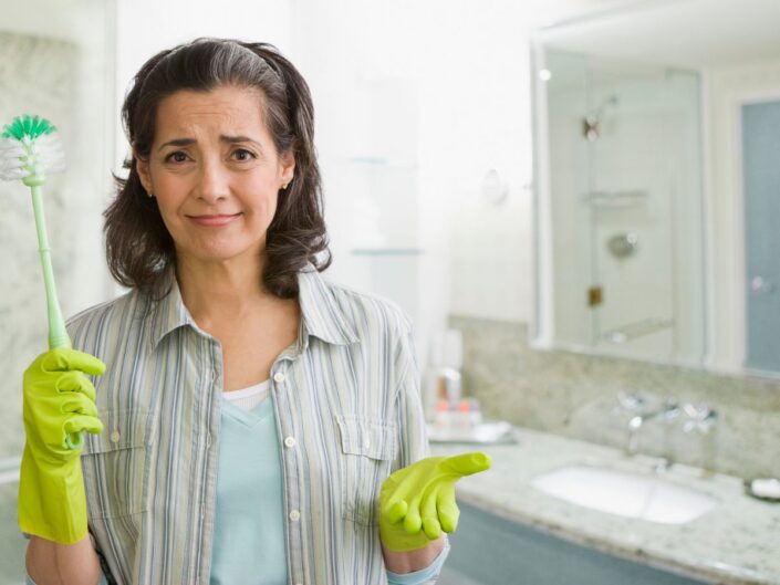 nő áll a fürdőszobában vécékefével a kezében