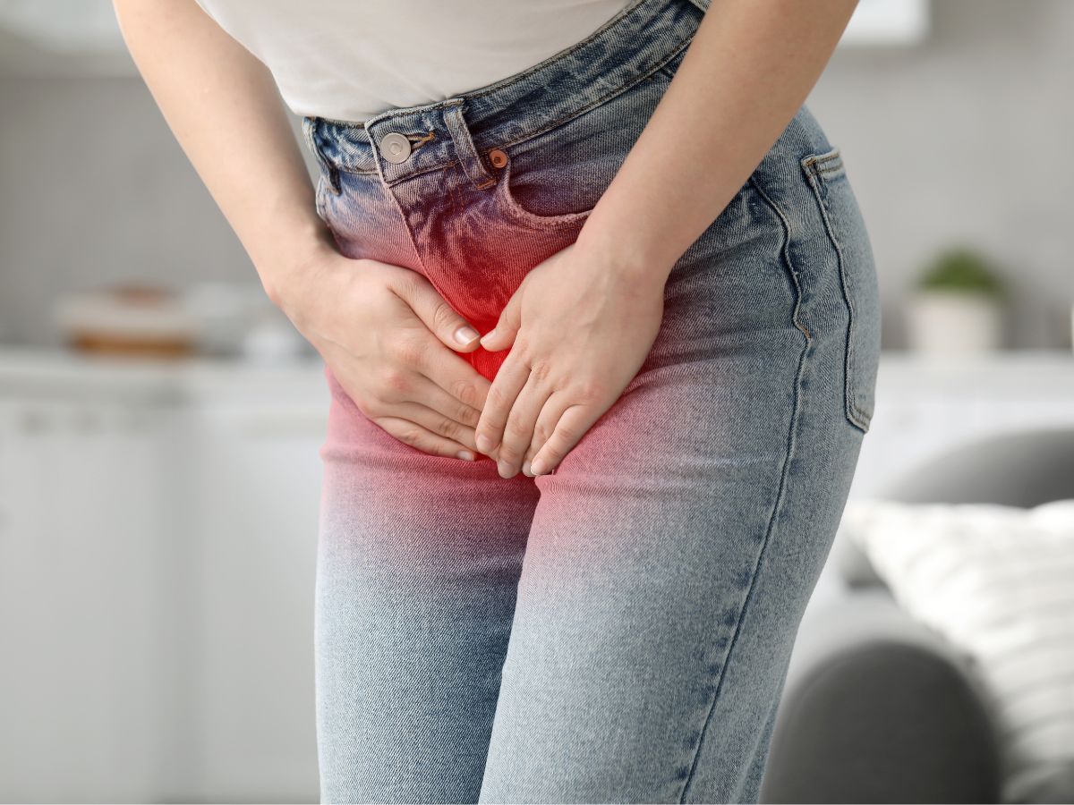 farmernadrágos nő fogja az ágyékát