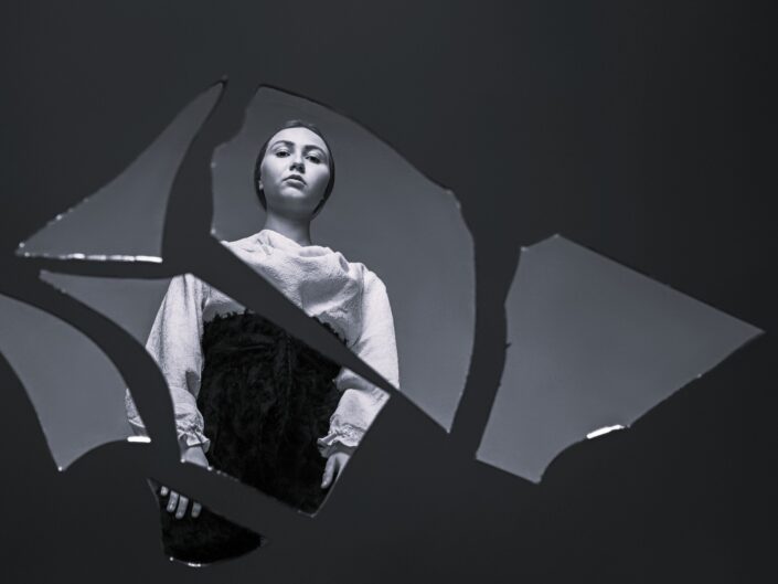 nő törött tükröt néz