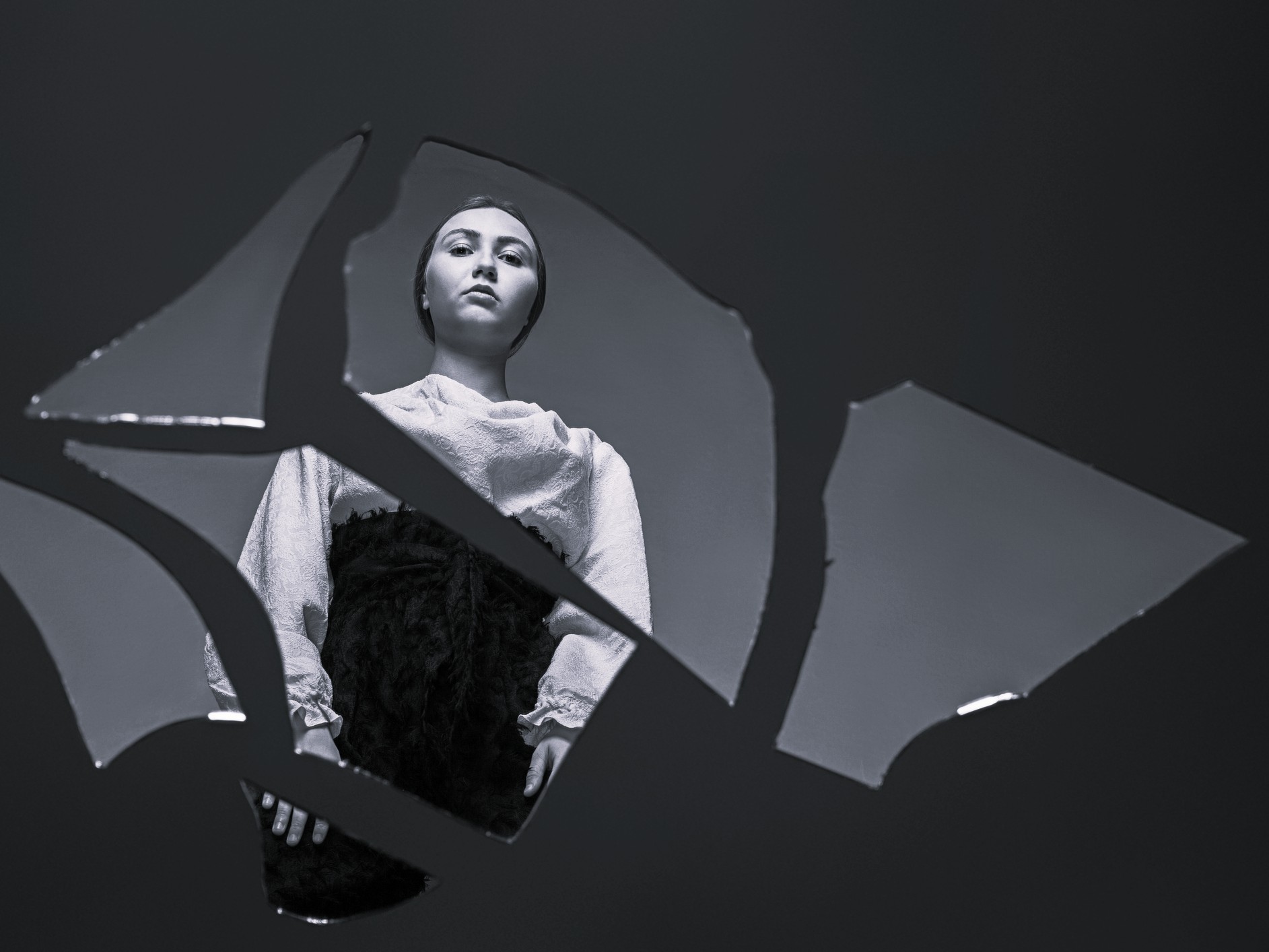 nő törött tükröt néz