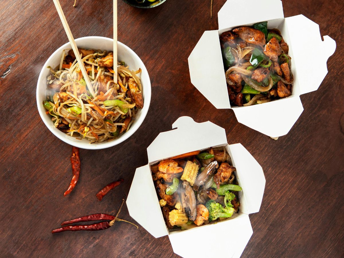 Elviteles kínai étel dobozokban és tálban fa asztalon