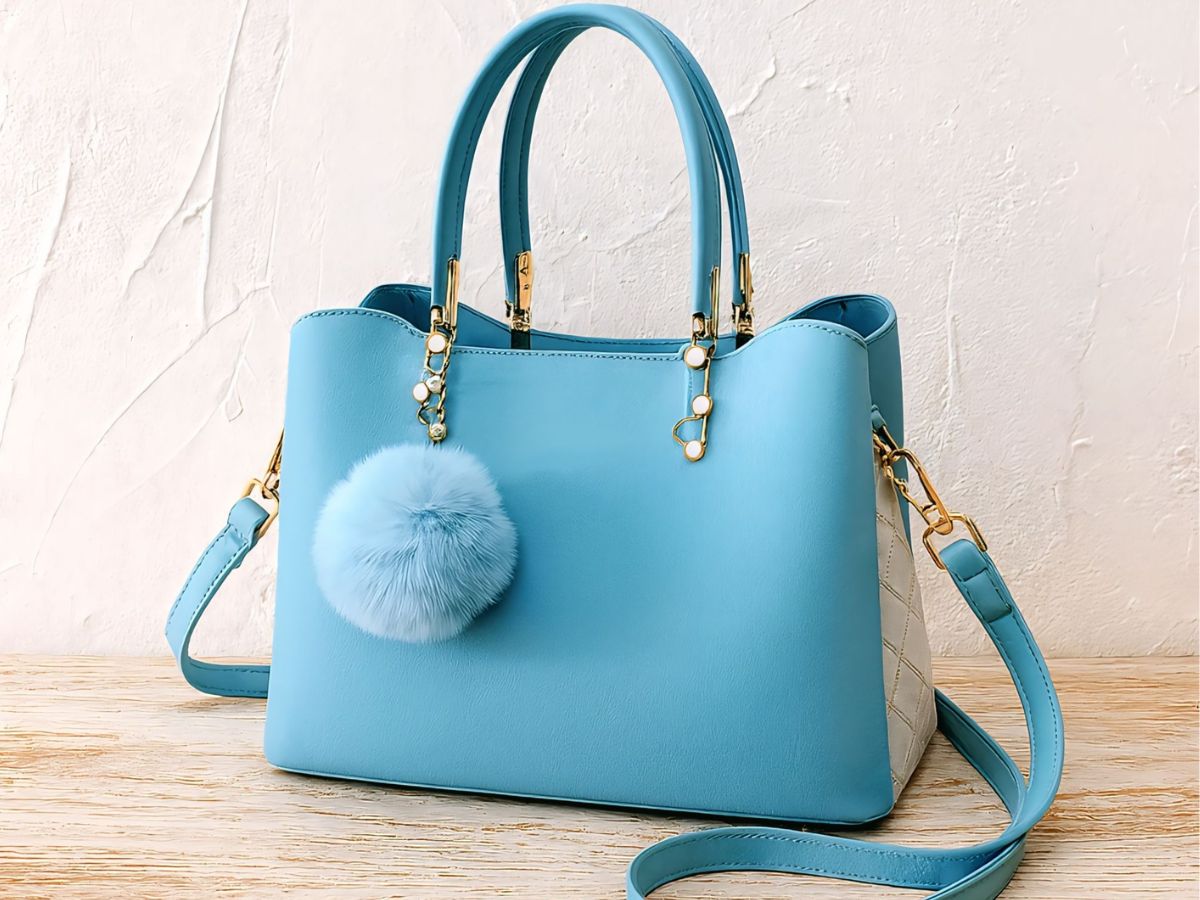 Babakék táska láncokkal és szőrös golyóval díszítve