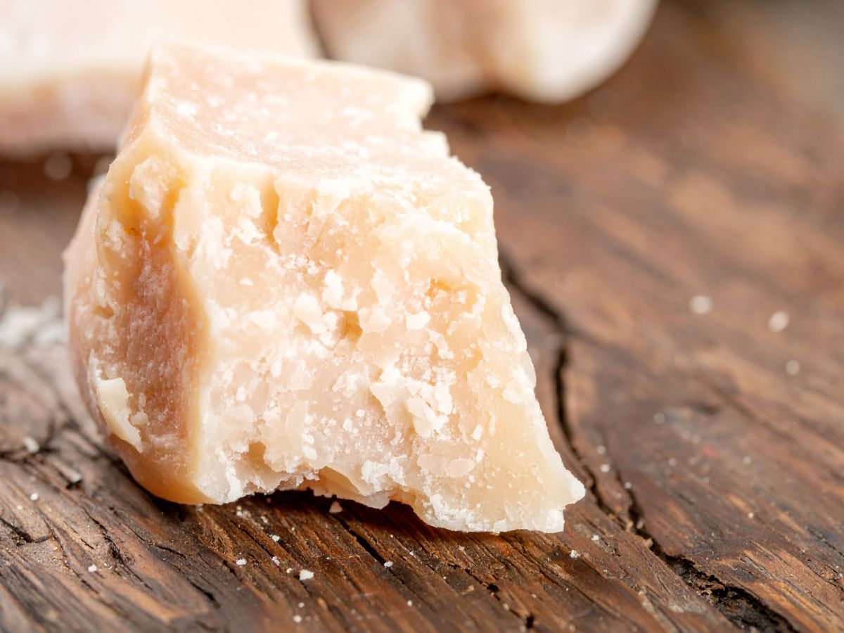 Egy darab parmezán durva fa tálcán