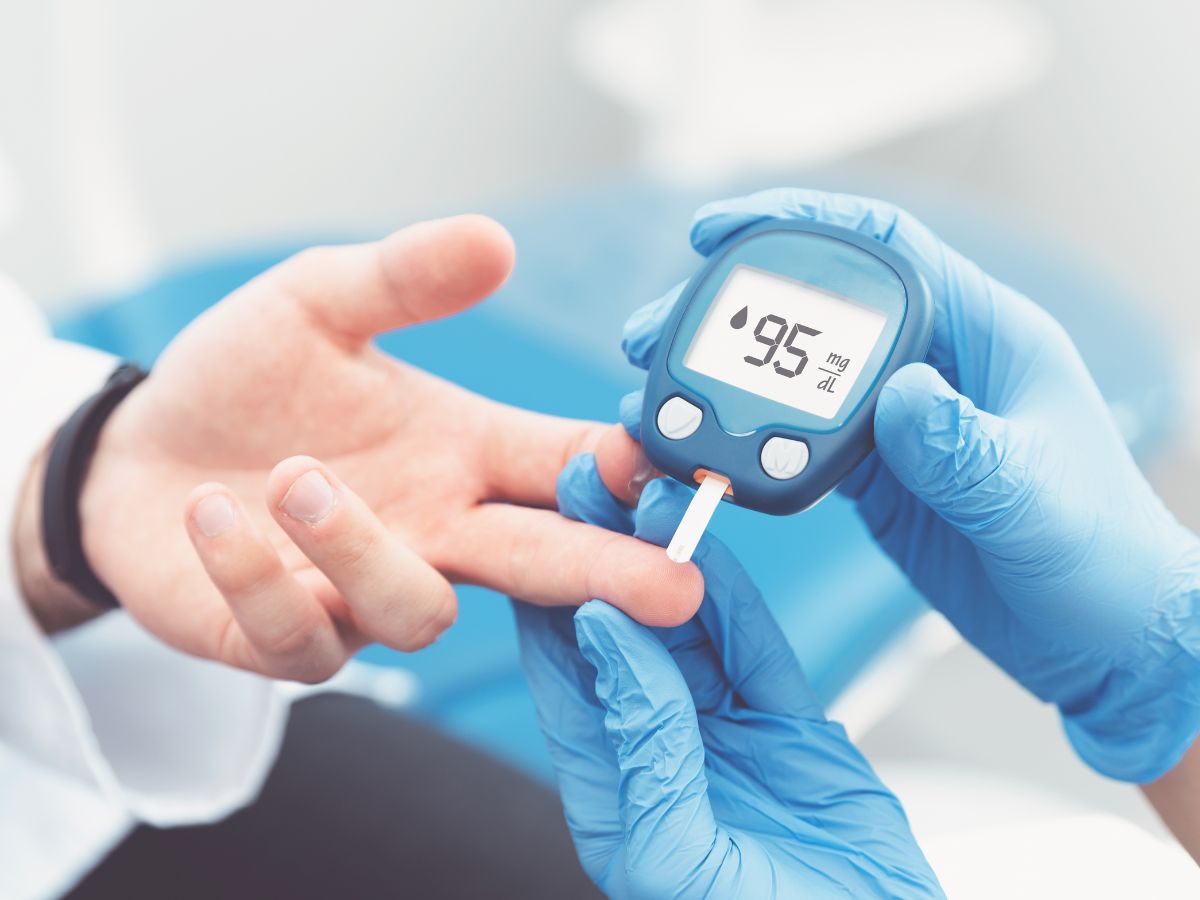 Gumikesztyűs kéz vércukoriszintet mér férfi kezén