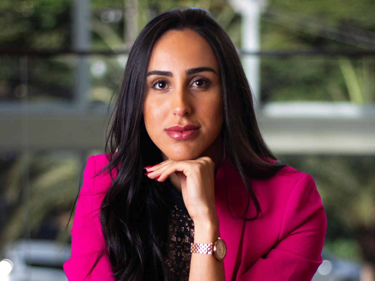 Barna hajú, kreol bőrű, temperamentumos fiatal női vezető ciklámen színű blézerben