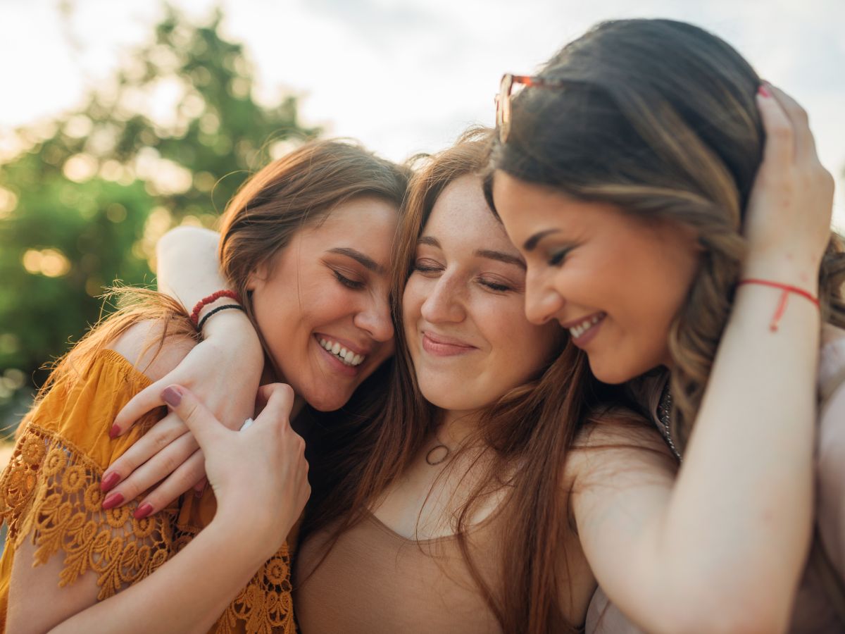 Három barátnő átöleli egymást boldogan