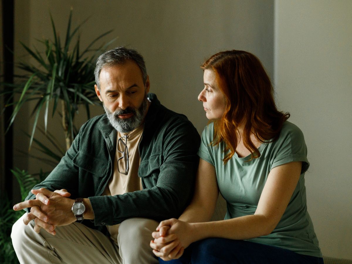 Negyvenes éveiben járó pár zöld árnyalatú ruhákban és lakásban komolyan beszélget egymással