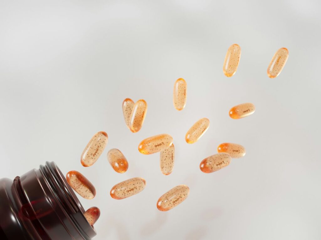 D-vitamin kapszulák kiborulnak a tartóedényből fehér háttéren