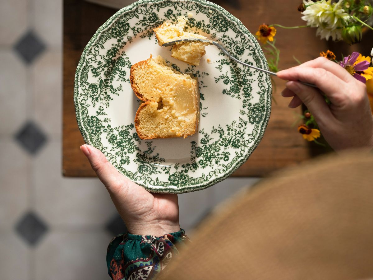 Értékes porcelántányérból ezsik süteményt nő felülnézetből