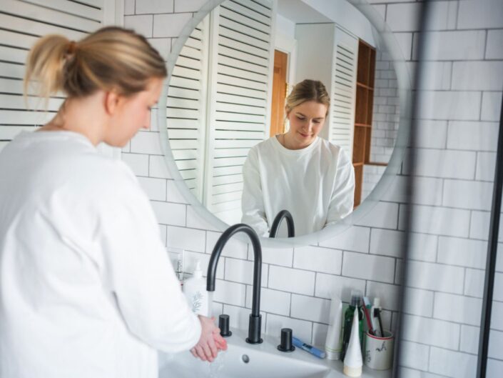 egy nő szép, tiszta fürdőszoobában kezet mos