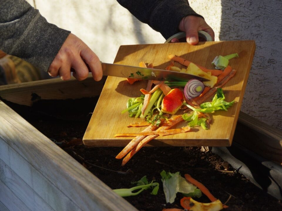 zöldséghulladékokat tesznek vágódeszkáról tárolóedénybe