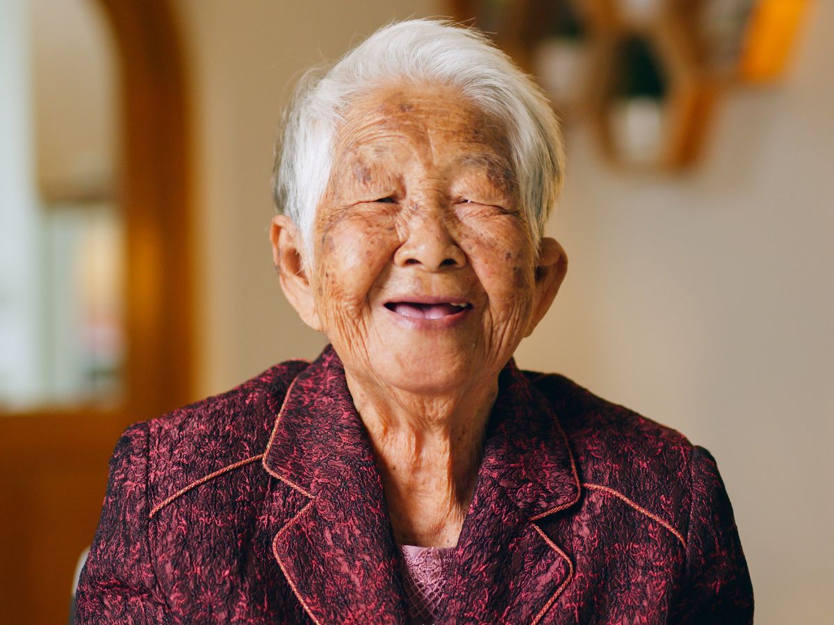 Idős japán nő boldogan mosolyog a kamerába