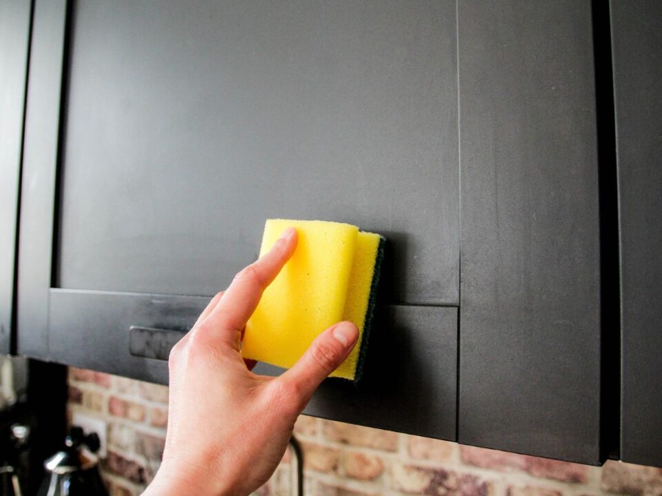 konyhaszekreny-tisztitas-hazi-modszer - Nők Lapja szivaccsal törlik a konyhaszekrényt
