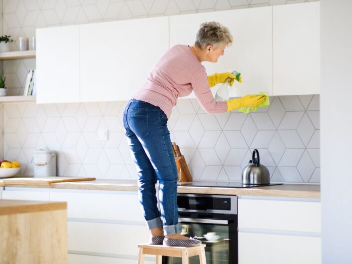 nő pucolja a konyhaszekrényt