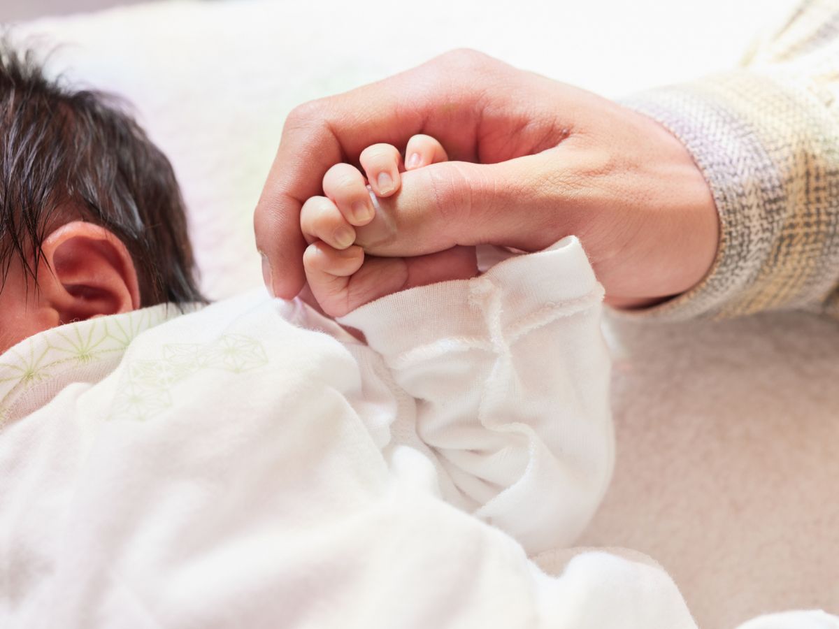újszülött kisbaba felnőtt kéz