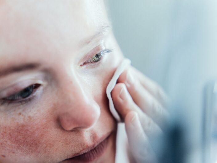 egy nő tisztítja a bőrét