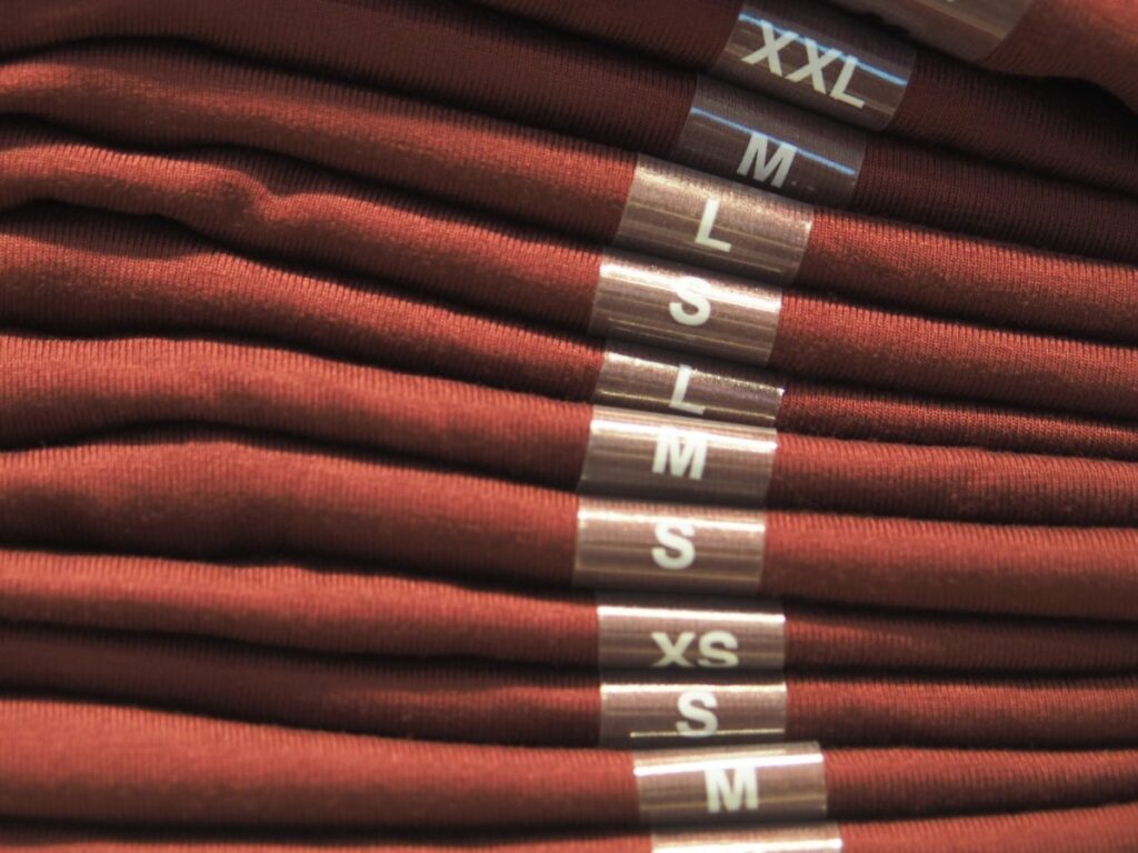 Rozsdabarna nadrágok egymáson összehajtva, a méretcímke látszik egymás felett