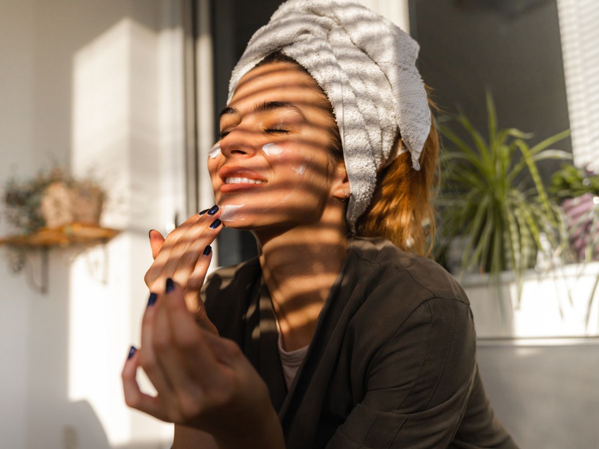 egy nő krémezi az arcát