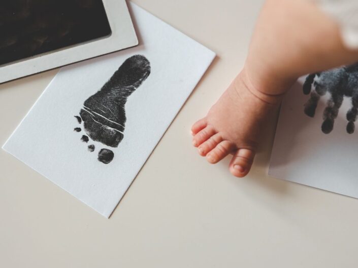 Kisbaba lába fekete láblenyomat mellett