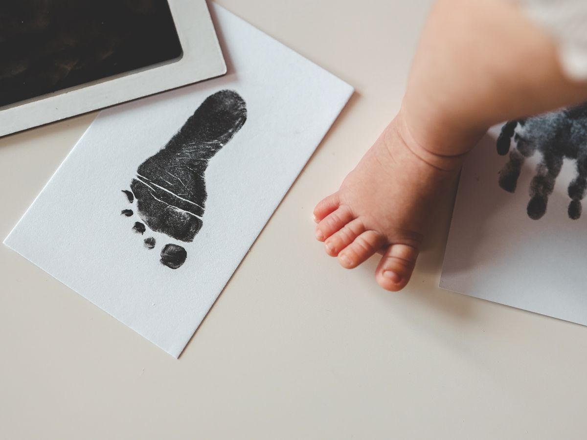 Kisbaba lába fekete láblenyomat mellett