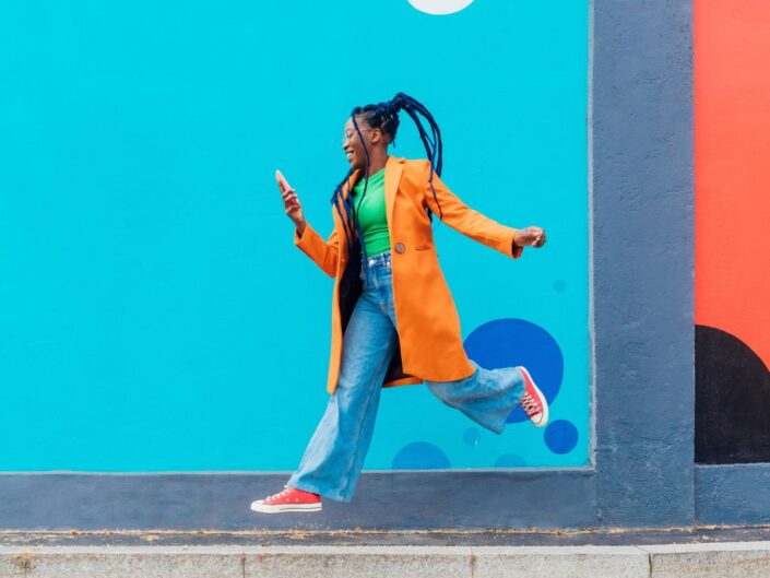 színes ruhába öltözött, vidám nő az utcán