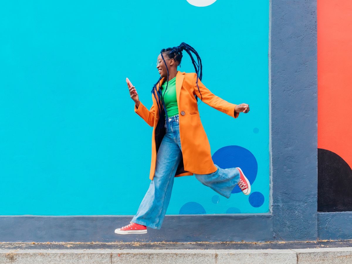 színes ruhába öltözött, vidám nő az utcán