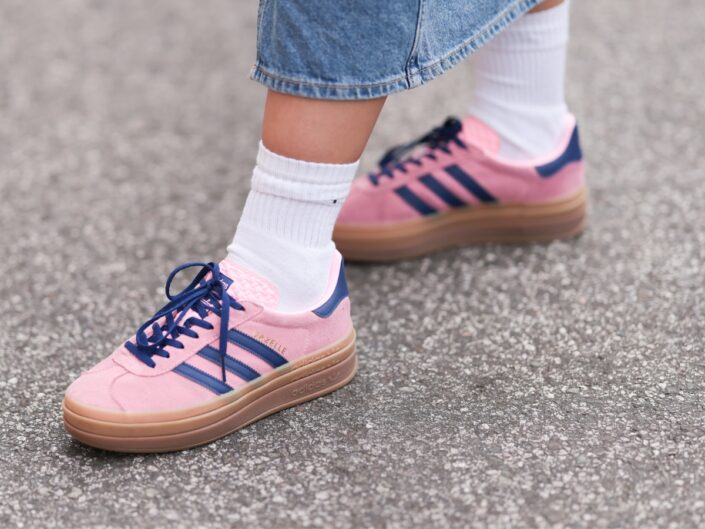 Street style képen egy rózsaszín tornacipős láb.