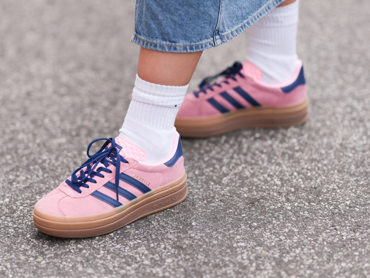 Street style képen egy rózsaszín tornacipős láb.