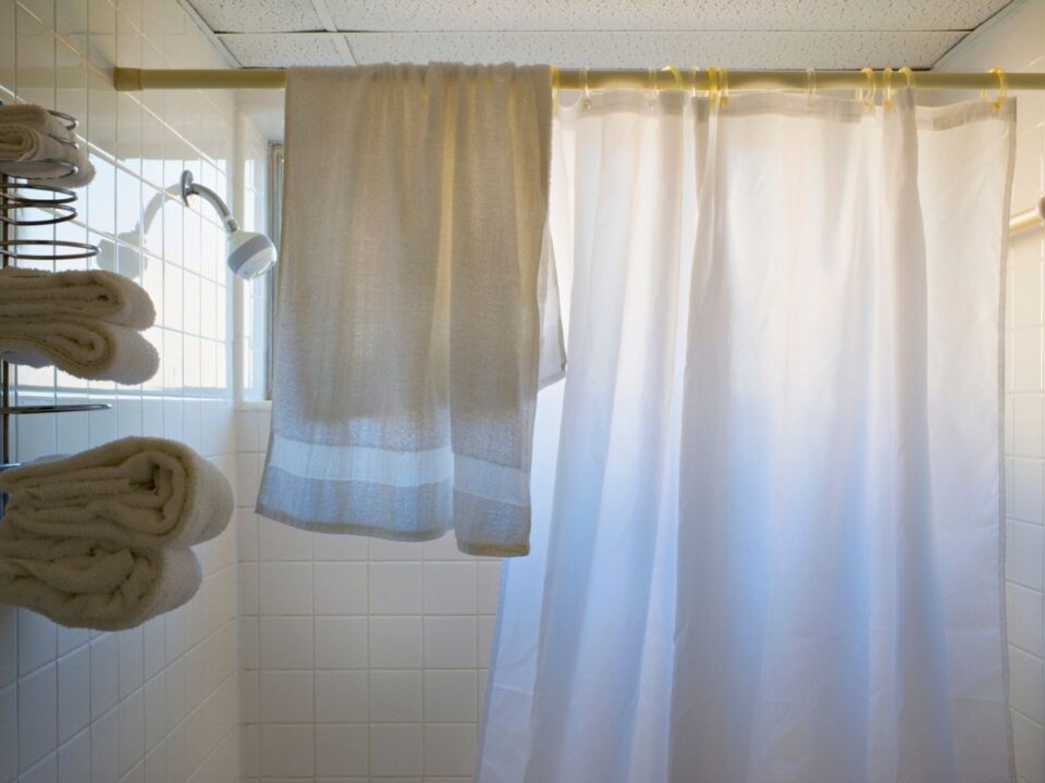 fürdőszoba elhúzott zuhanyfüggöny és törölközők