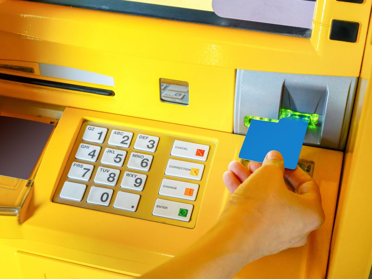 Sárga bankautomatába kék bankkártyát dug női kéz