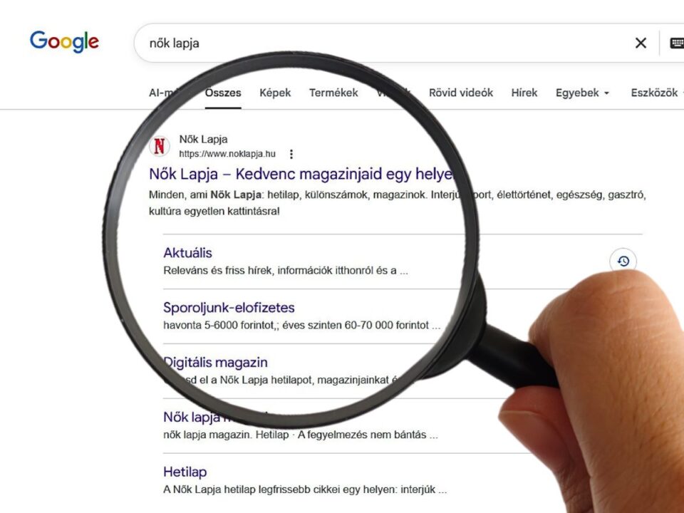 Nagyító alatt látható egy Google-keresési találati oldal, ahol a Nők Lapja weboldala szerepel kiemelten. A képernyőn a keresőmezőben a „nők lapja” kifejezés olvasható.
