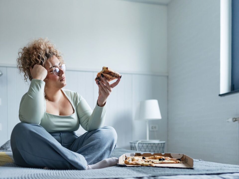 egy nő szomorú és pizzát eszik