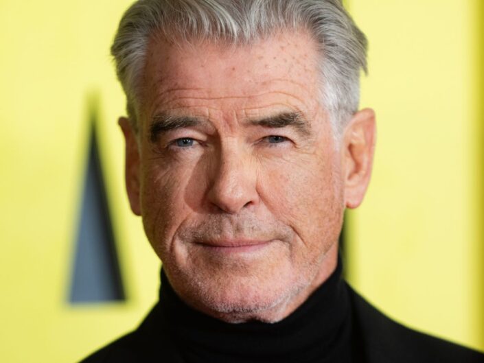 Pierce Brosnan közeli portré fekete garbóban, sárga háttér előtt