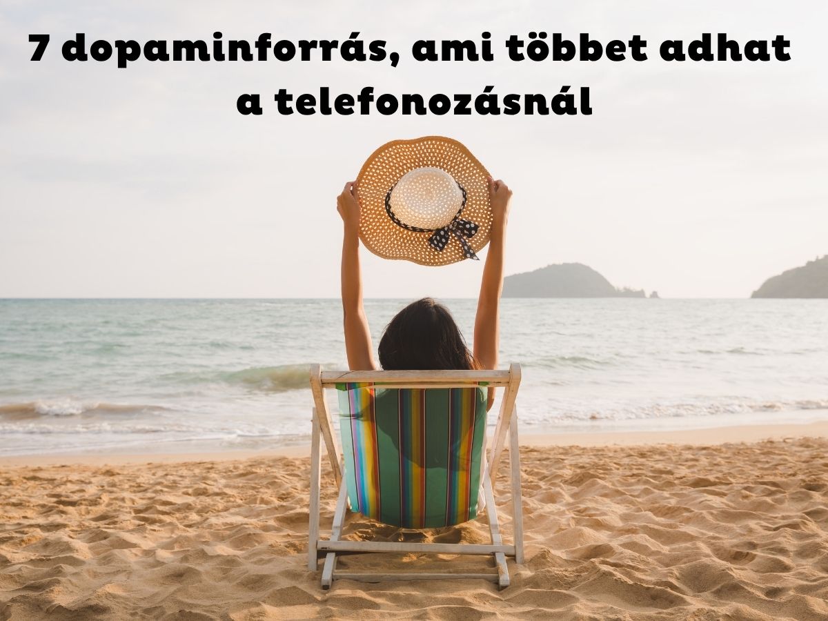 Nő a tengerparton nyugágyban ülve emeli a feje fölé szalmakalapját hátulról fotózva