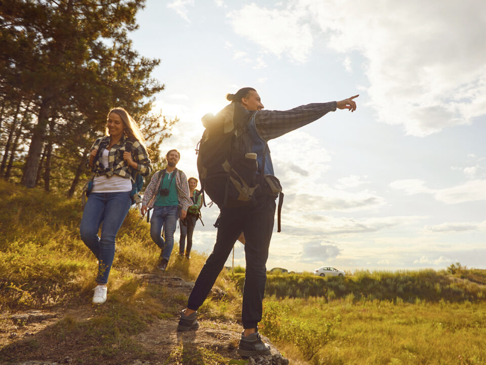 Young people with backpacks walking in the forest - Nők Lapja