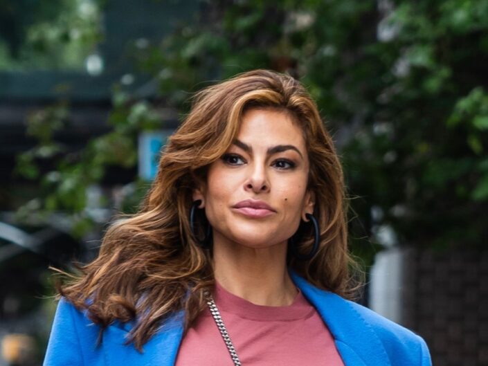 Eva Mendes kibontott hajjal, kék kabátban és piros pólóban utcán