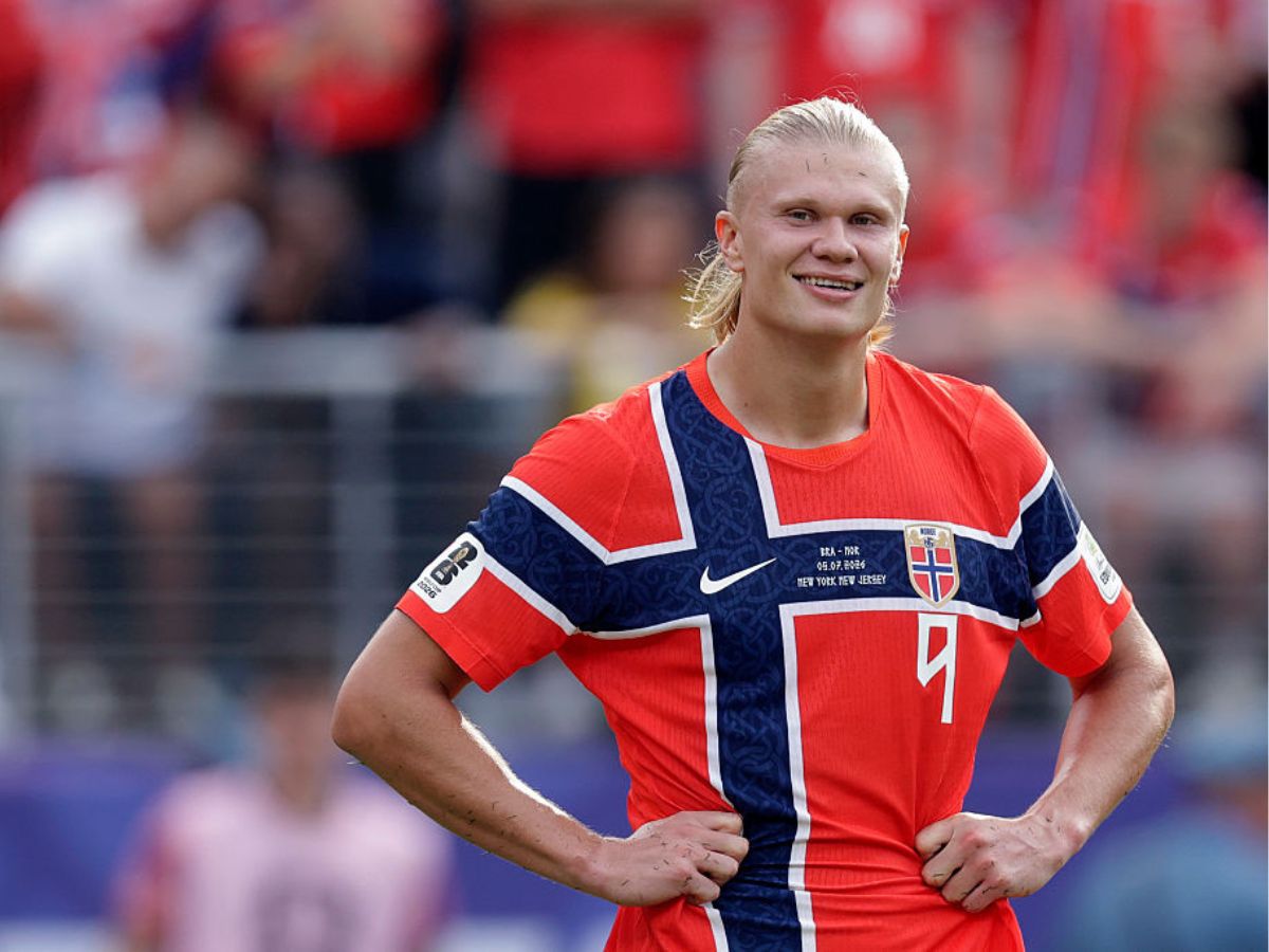 Erling Haaland norvég focista csípőre tett kézzel mosolyog a focipályán
