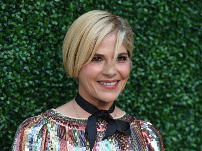 Selma Blair portré sövényfal előtt színes, csillogó ruhában