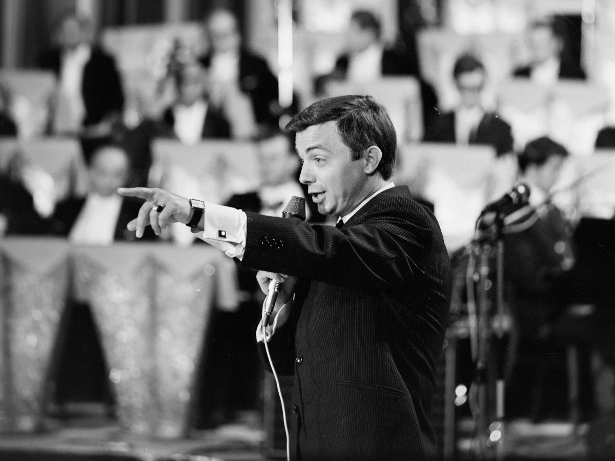 Aradszky László az Erkel Színházban az 1968-as Táncdalfesztivál döntőjén. A fekete fehér képen deréktól felfelé látszik oldalról fotózve, fekete öltönyben énekel, bal karjával a közönségre mutatva